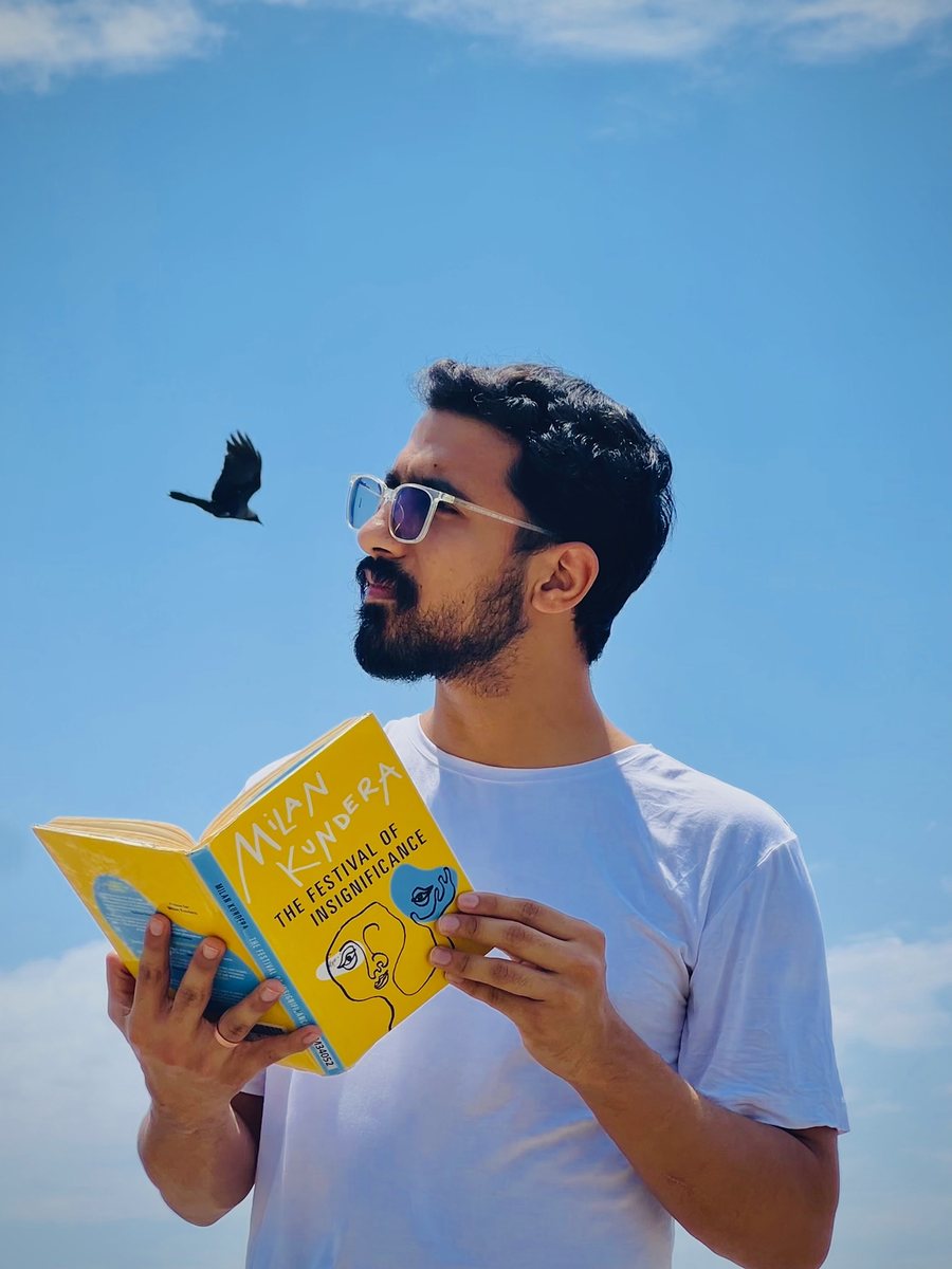 Karan Kapoor reading Milan Kundera's The Festival of Insignificance, a crow flying past